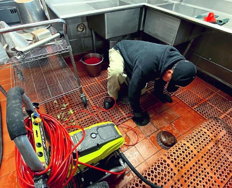 a man unblocking a drain inside a house